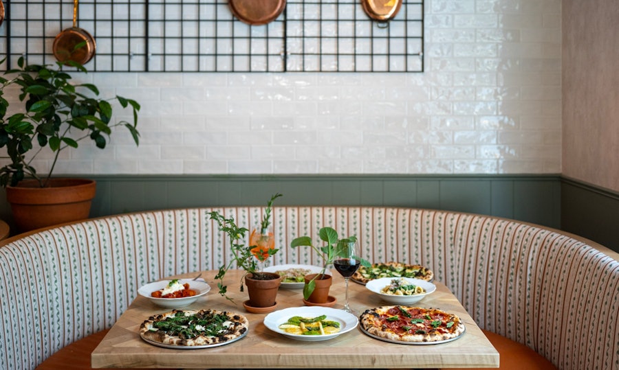 A spread of Rosemary's Midtown's signature dishes on a table in a corner booth.