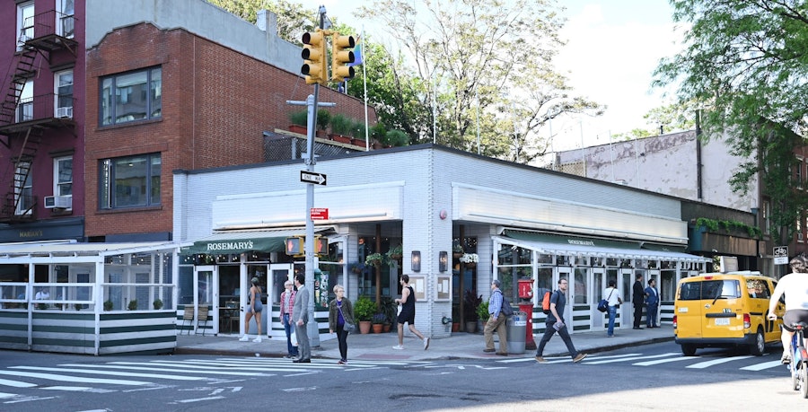 The exterior of Rosemary's on the corner of 10th St. and Greenwich Ave, with foliage from the rooftop garden visible.